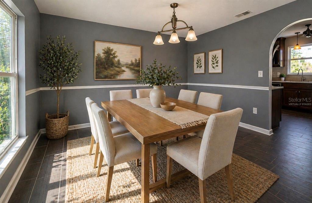 A living room features a sectional sofa, a round coffee table, and a television console — 239 CURTIS AVENUE, GROVELAND, FL
