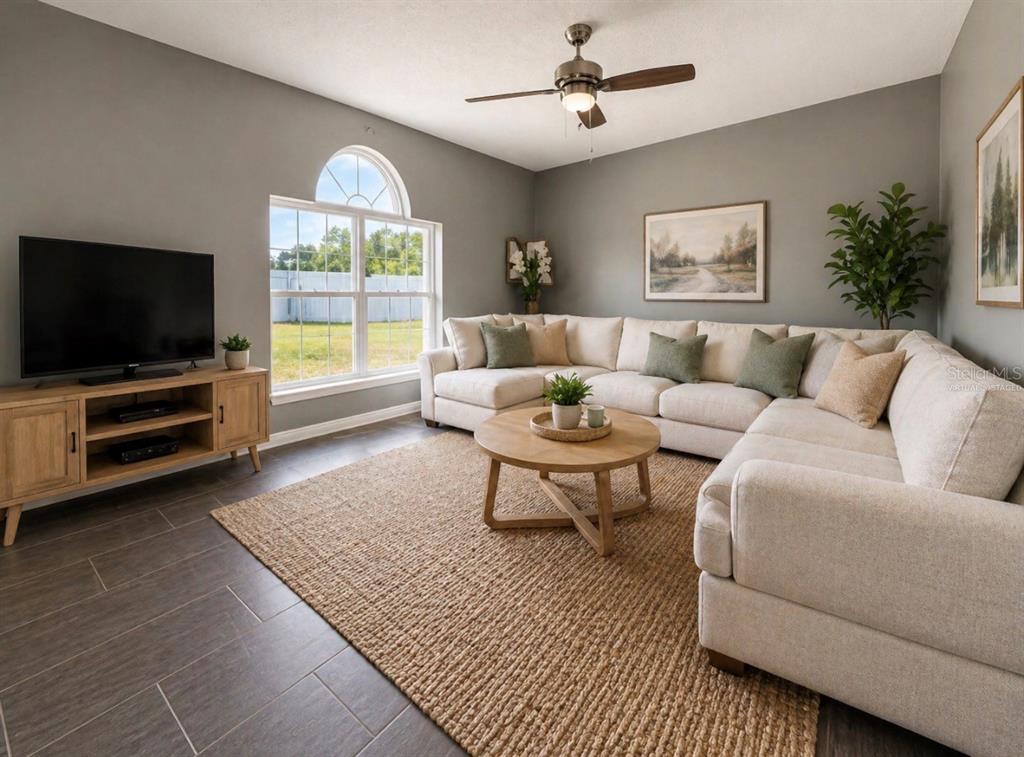 A bedroom features a bed with a green runner, two nightstands, and a ceiling fan — 239 CURTIS AVENUE, GROVELAND, FL