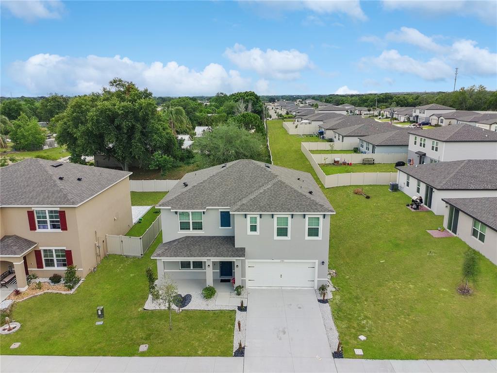 An aerial view shows a two-story suburban house with a gray exterior and shingled roof — 2085 DOE RUN DRIVE, DAVENPORT, FL