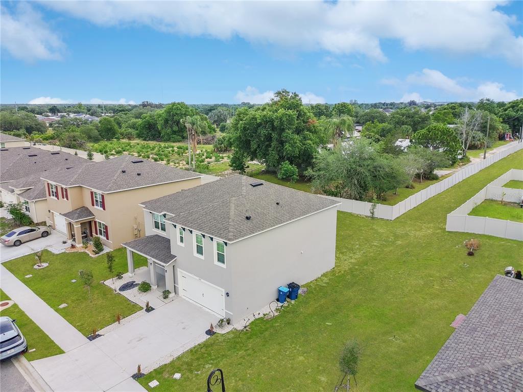 An aerial view shows a two-story suburban house with a large side yard and driveway — 2085 DOE RUN DRIVE, DAVENPORT, FL