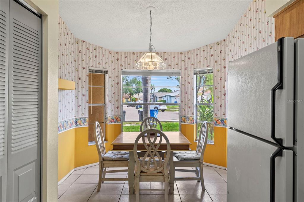 A bedroom features a green quilt on a metal bed frame, ceiling fan, and sliding doors — 8601 TWIN FARMS PL, TAMPA, FL