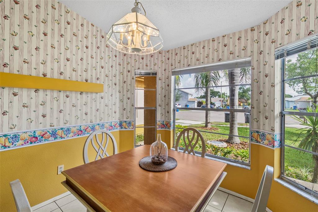 A bedroom features a metal bed frame, green bedding, a ceiling fan, and sliding glass doors — 8601 TWIN FARMS PL, TAMPA, FL