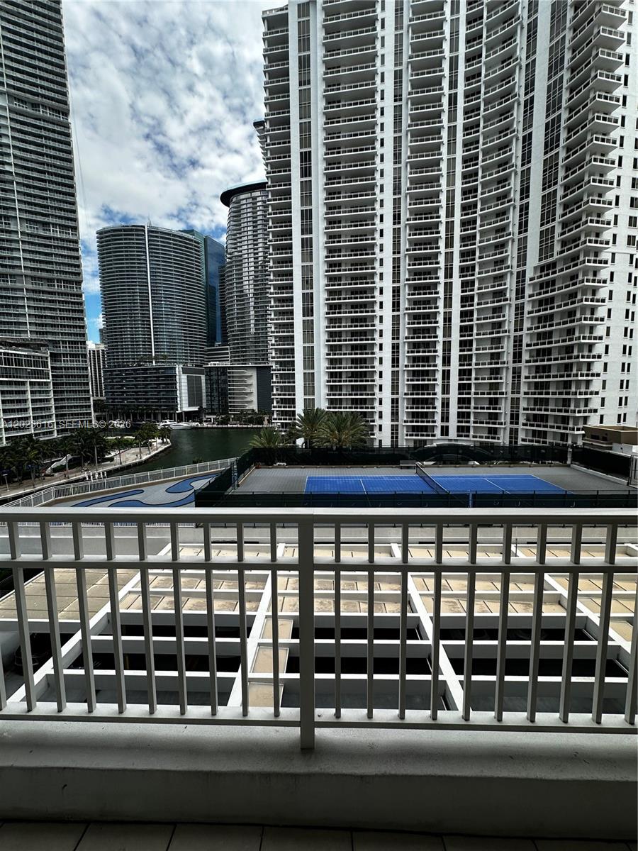 A balcony view overlooks a tennis court, a canal, and several high-rise apartment buildings — 801 Brickell Key Blvd # 906, Miami FL 33131, MIAMI, FL
