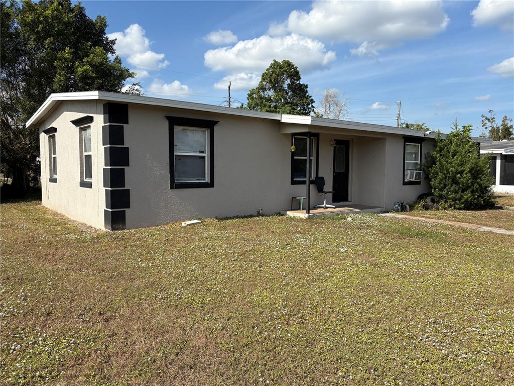 A single-story house with tan stucco walls and dark trim sits on a grassy lot — 6129 FREEMONT STREET, NORTH PORT, FL