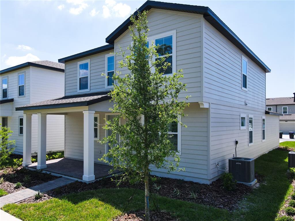 A two-story house with light gray siding, a covered front porch, and a paved walkway — 11165 GREEN CITRON ALLEY, WINTER GARDEN, FL