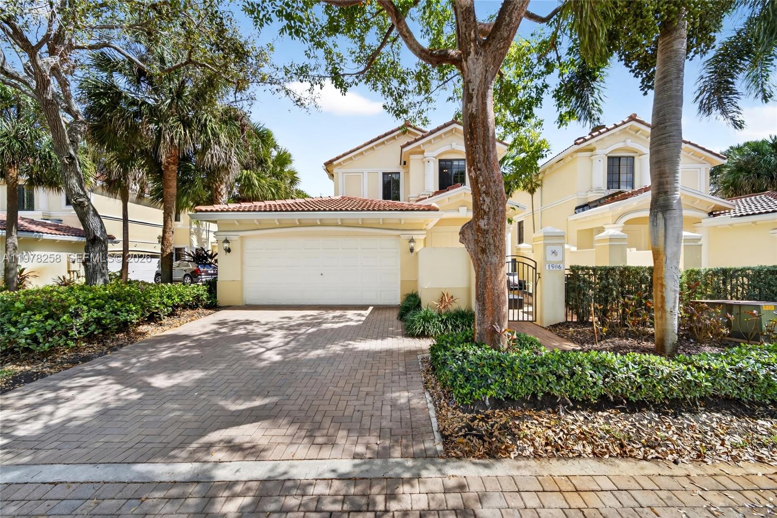 A two-story yellow house with a tiled roof, a two-car garage, and a brick driveway — 1506 Passion Vine Cir # 3, Weston FL 33326, WESTON, FL