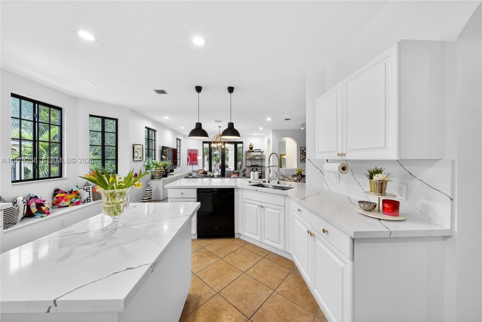 A white kitchen features marble countertops, a black dishwasher, and a window seat with pillows — 1506 Passion Vine Cir # 3, Weston FL 33326, WESTON, FL