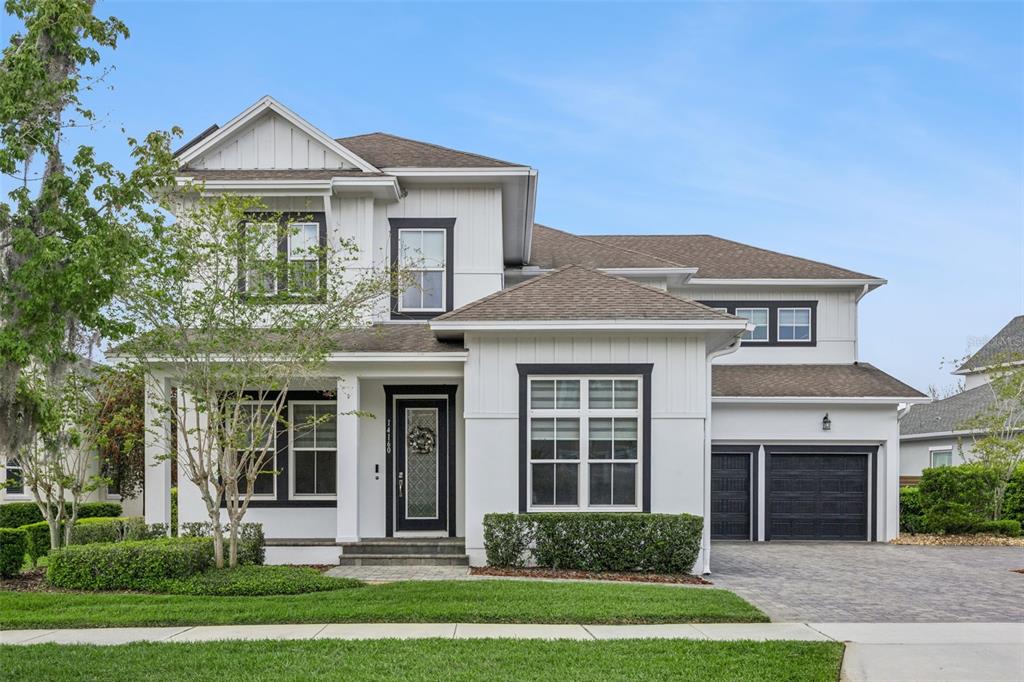 A two-story white house with black trim, a front porch, and a two-car garage — 14160 ELIOT AVENUE, ORLANDO, FL