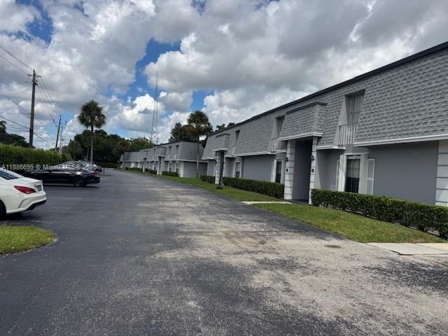A row of gray two-story apartment buildings sits beside a parking lot under a cloudy sky — 360 NW 69th Ave # 202, Plantation FL 33317, PLANTATION, FL