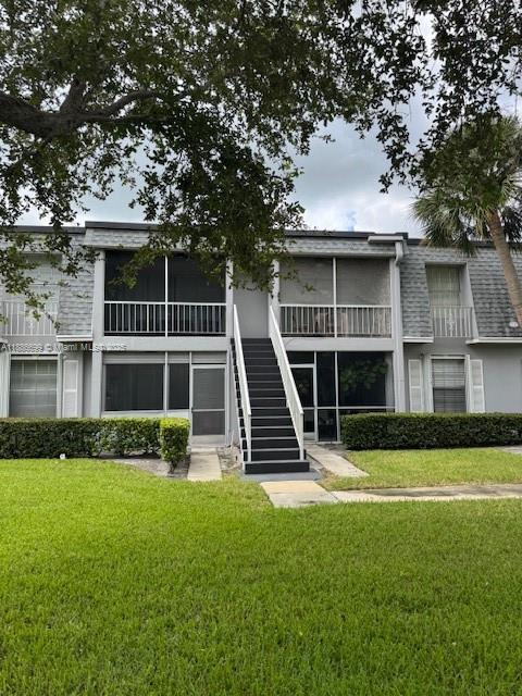 A two-story apartment building features a central outdoor staircase and screened-in balconies — 360 NW 69th Ave # 202, Plantation FL 33317, PLANTATION, FL