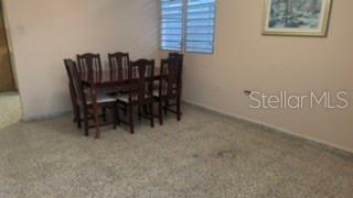 A dining room features a dark wood table with six chairs on beige carpet — 39 SIMPLICIO, JUNCOS, PR