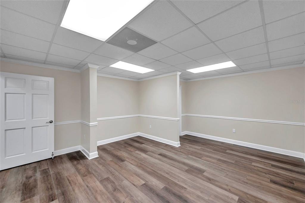 An empty office space features light-colored walls, wood-look flooring, and a drop ceiling — 2401 W BAY DRIVE UNIT 410, LARGO, FL