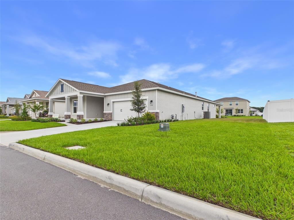 A single-story suburban house with a gray stucco exterior and a two-car garage — 5717 SW 71ST COURT, OCALA, FL