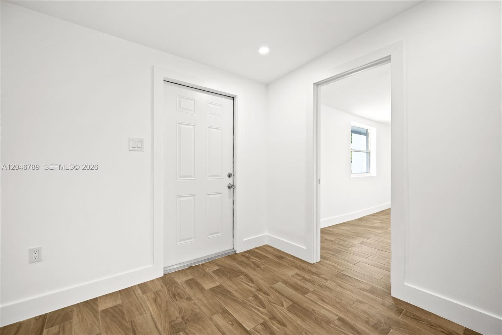 An interior view shows a white door and an open doorway leading to a room — MIAMI, FL