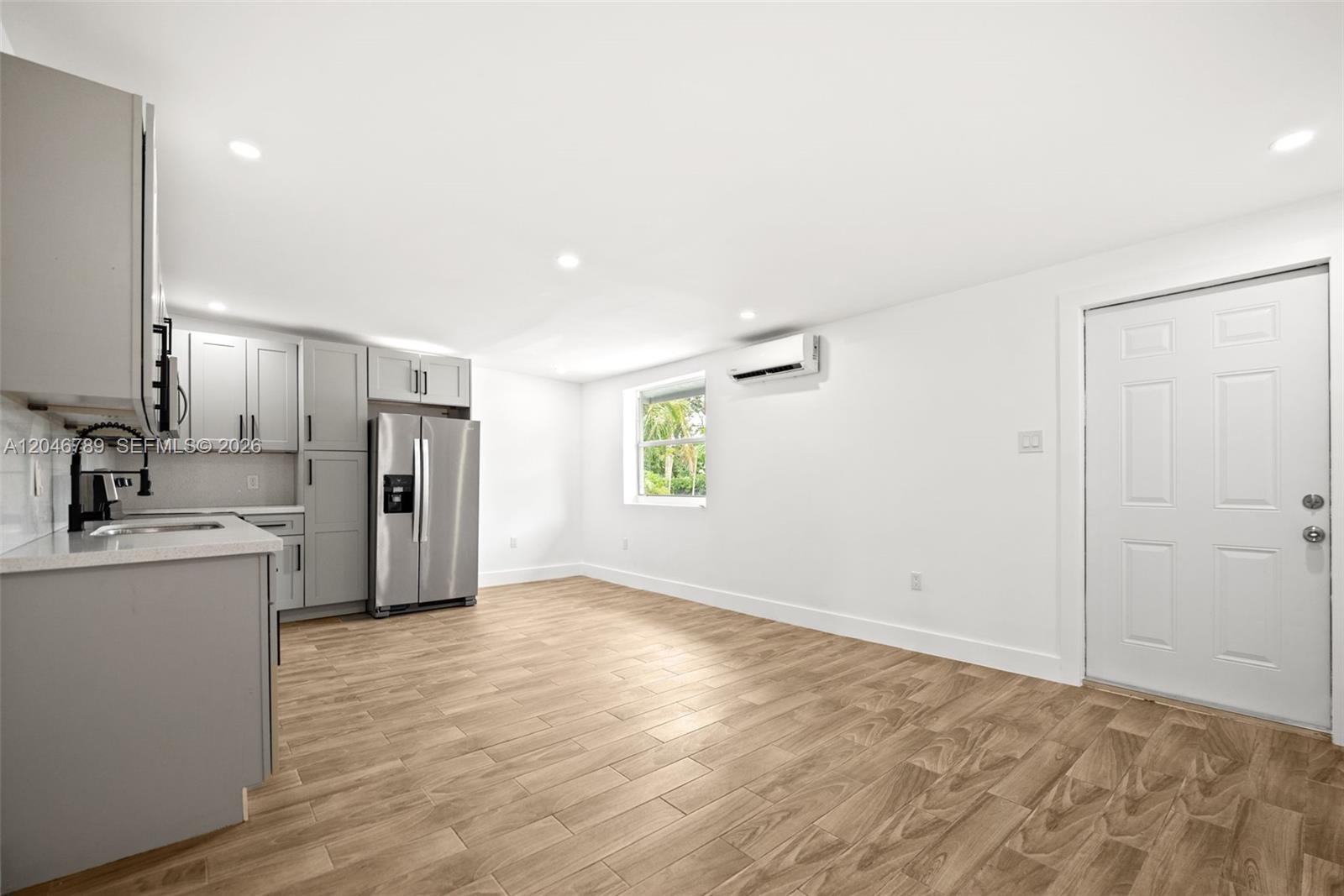 This kitchen features gray cabinets, stainless steel appliances, and light wood-look tile flooring — MIAMI, FL