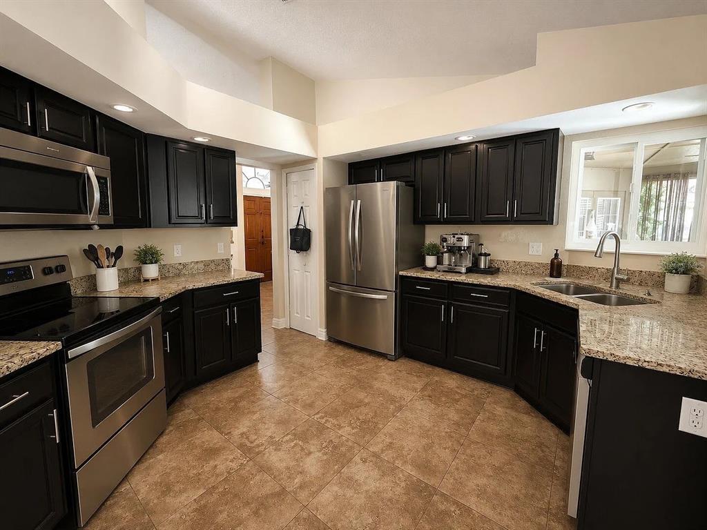 An empty room with vaulted ceilings, light gray walls, and brown tile flooring — 2406 ABALONE BOULEVARD, ORLANDO, FL