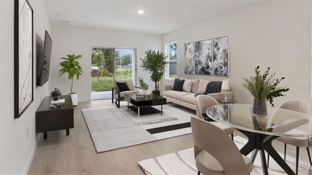 A modern living and dining area with light wood floors, neutral furniture, and sliding doors — 1917 HOWARD MESA DRIVE, KISSIMMEE, FL