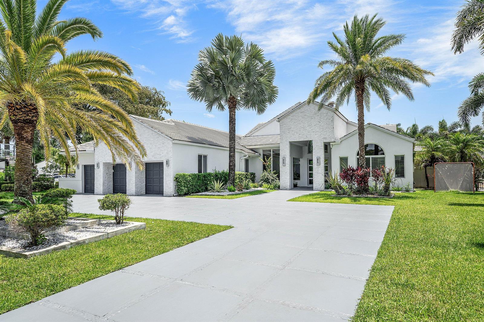 A white single-story house with a three-car garage, palm trees, and a paved driveway — 3828 NW 53rd Street, Boca Raton FL 33496, BOCA RATON, FL