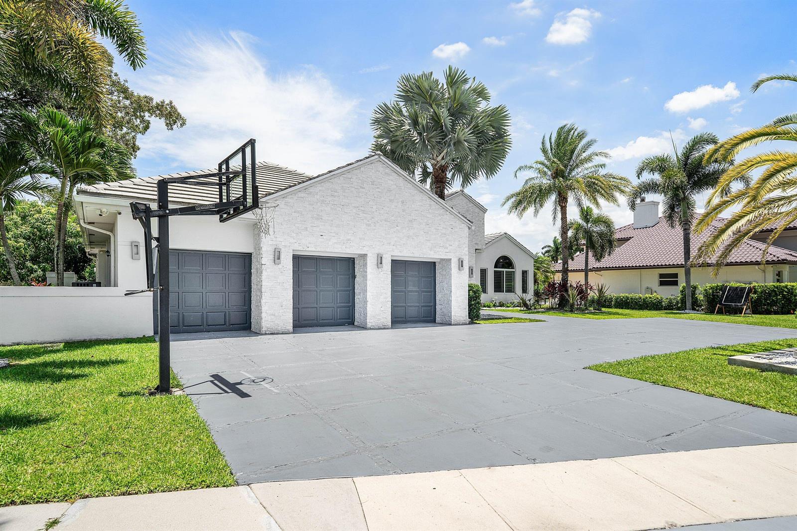 A white brick house with a three-car garage and a basketball hoop in the driveway — 3828 NW 53rd Street, Boca Raton FL 33496, BOCA RATON, FL
