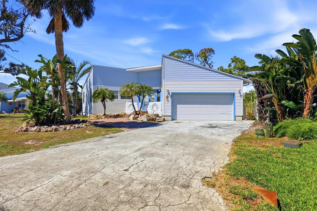 A light blue house with a two-car garage and a cracked concrete driveway — 1052 KANT STREET, ENGLEWOOD, FL