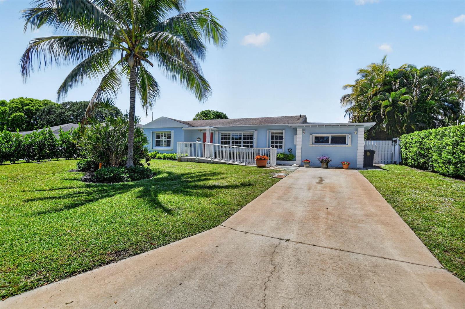 A light blue single-story house features a palm tree, a wheelchair ramp, and a driveway — 277 NW 3rd Court, Boca Raton FL 33432, BOCA RATON, FL