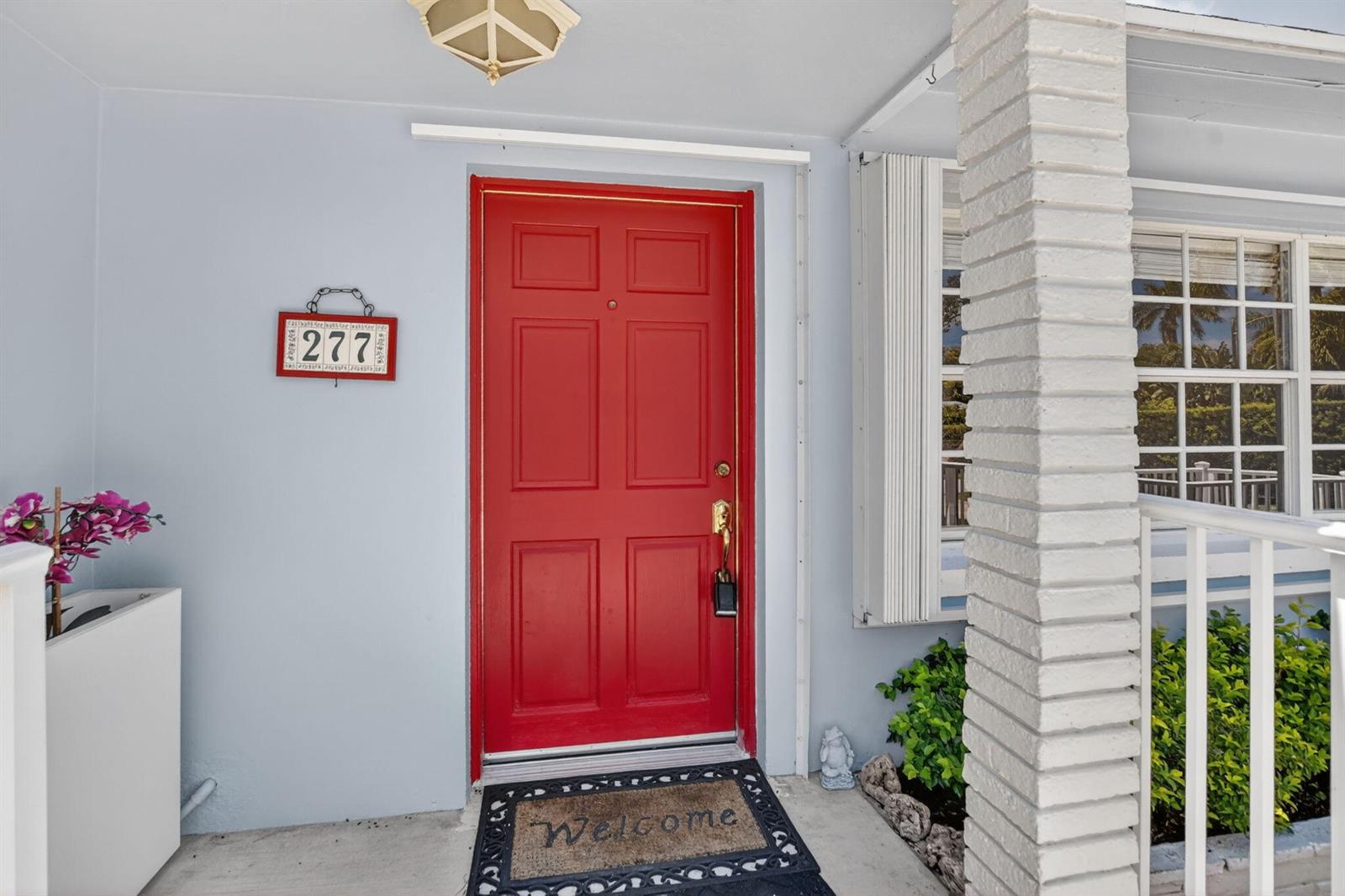 A bright red front door with a house number sign sits on a porch — 277 NW 3rd Court, Boca Raton FL 33432, BOCA RATON, FL