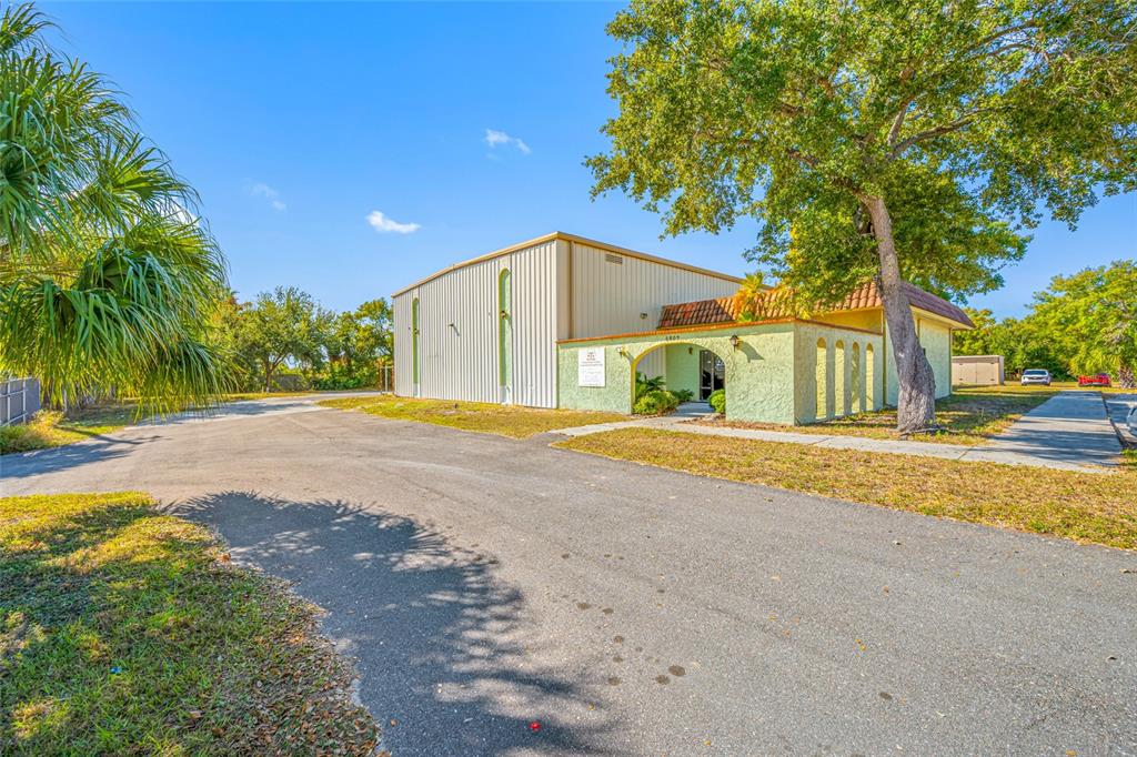 A two-story building with a metal-sided section and a stucco entrance under a tiled roof — 5802 N OCCIDENT STREET, TAMPA, FL