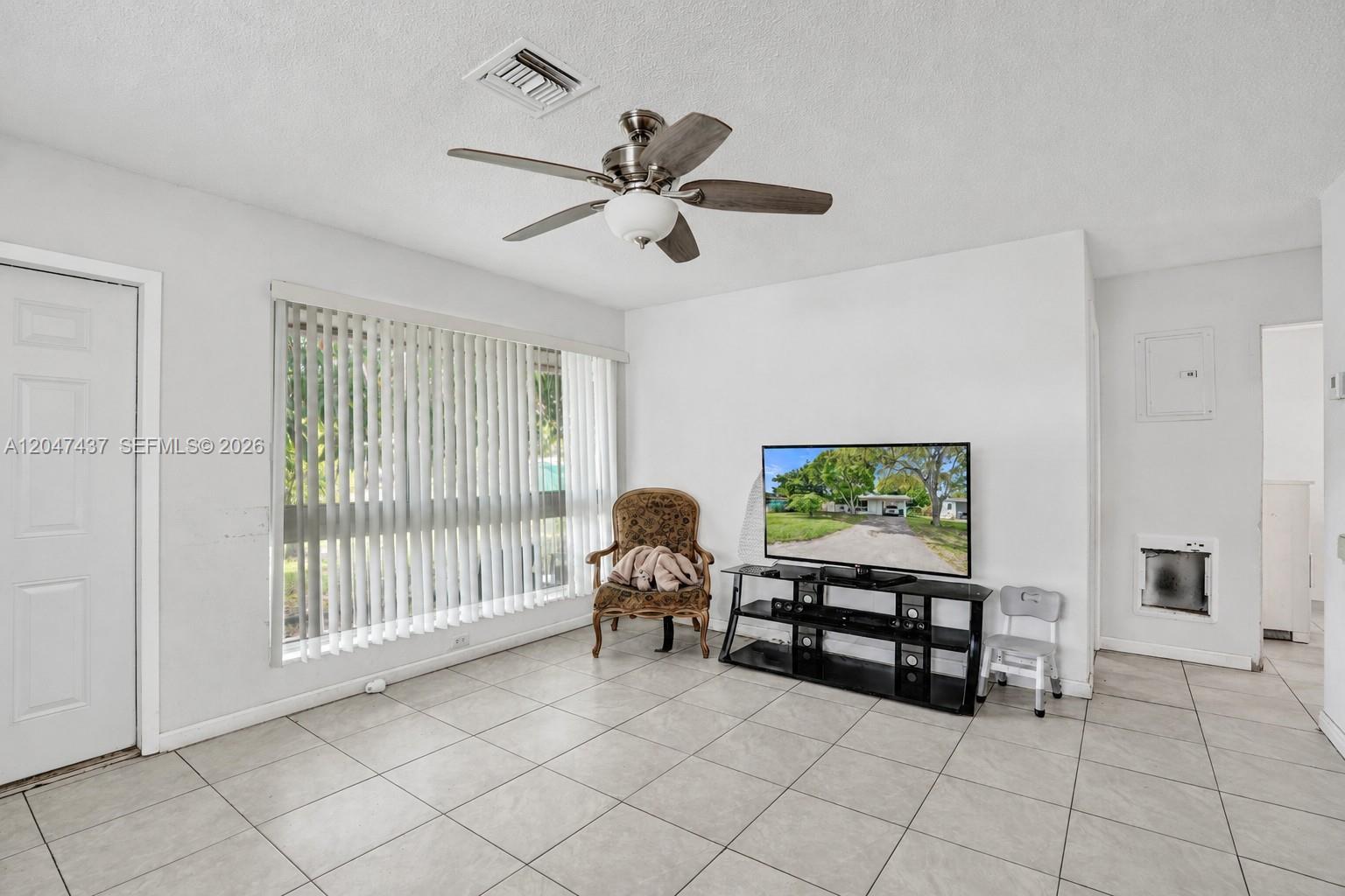 A living room features white walls, tile flooring, a ceiling fan, and a television console — 6358 SW 20th Ct, Miramar FL 33023, MIRAMAR, FL