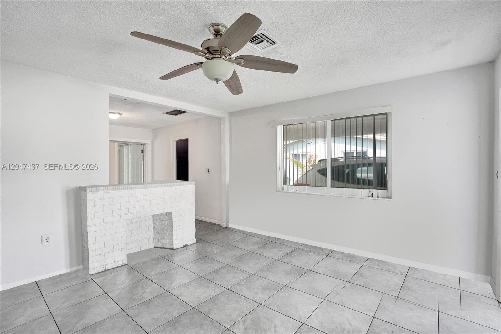 A room with gray tile flooring, a white brick half-wall, and a ceiling fan — 6358 SW 20th Ct, Miramar FL 33023, MIRAMAR, FL