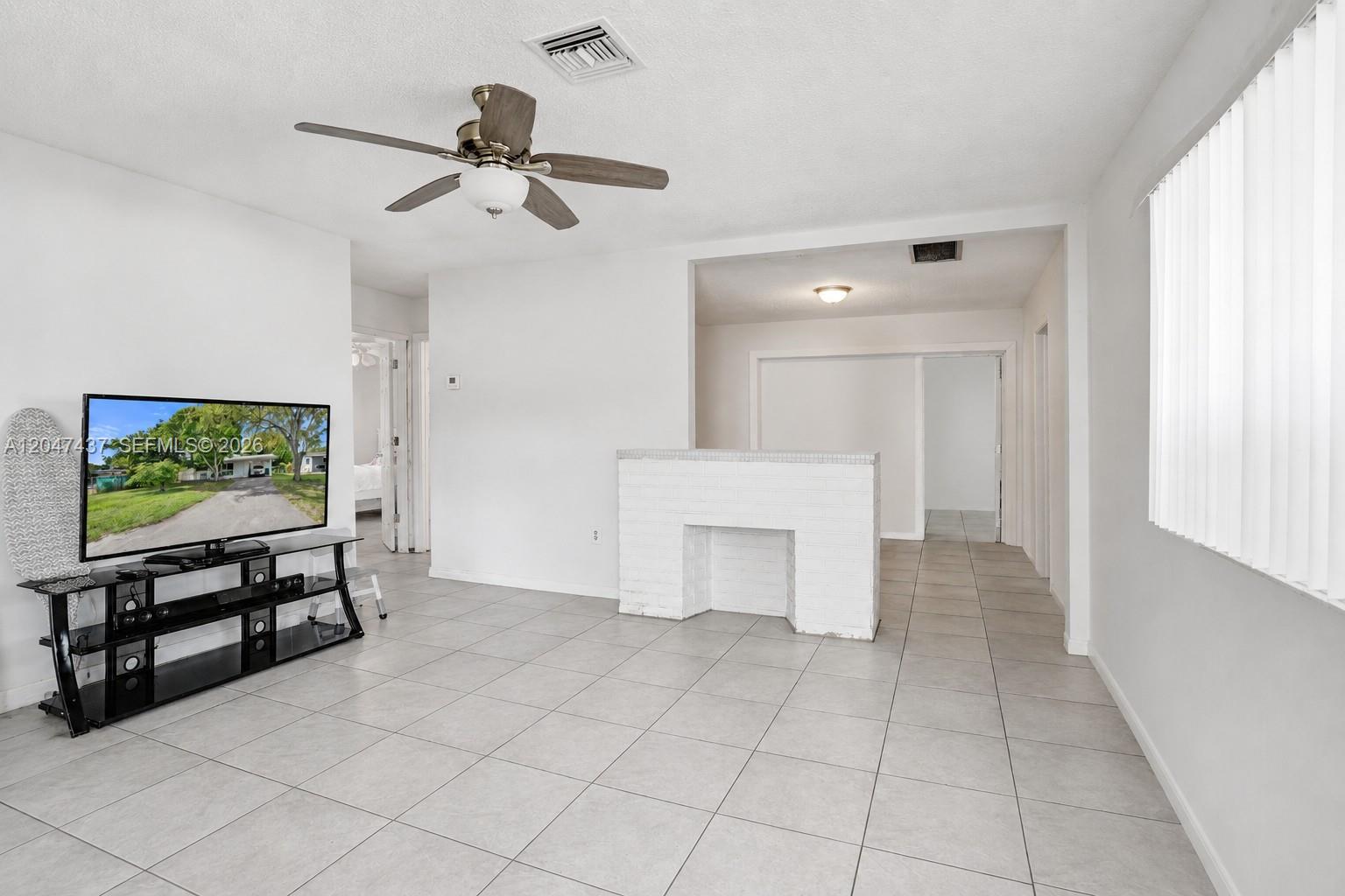 A living room features white tile floors, a ceiling fan, and a white brick partition — 6358 SW 20th Ct, Miramar FL 33023, MIRAMAR, FL
