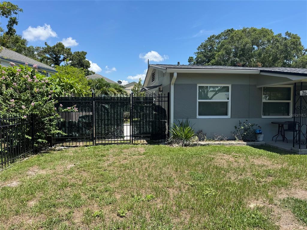 The exterior of a gray house features a black metal fence and a grassy yard — 2845 9TH AVENUE N, ST PETERSBURG, FL