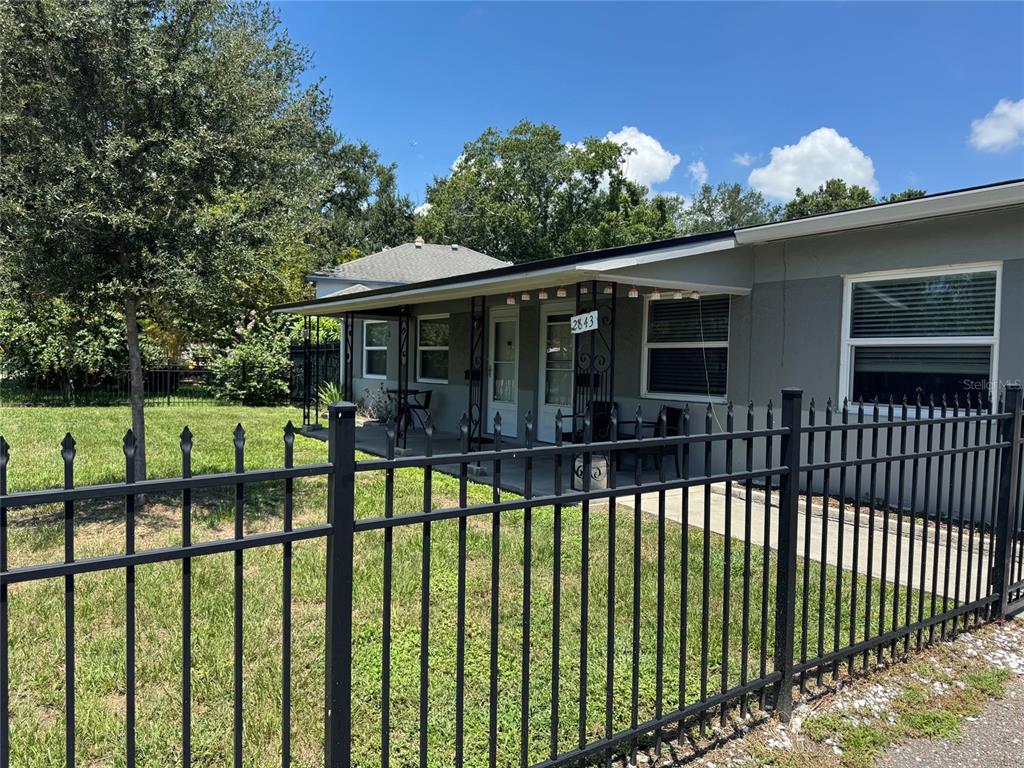 A single-story house with a covered porch and black metal fence sits on a lawn — 2845 9TH AVENUE N, ST PETERSBURG, FL