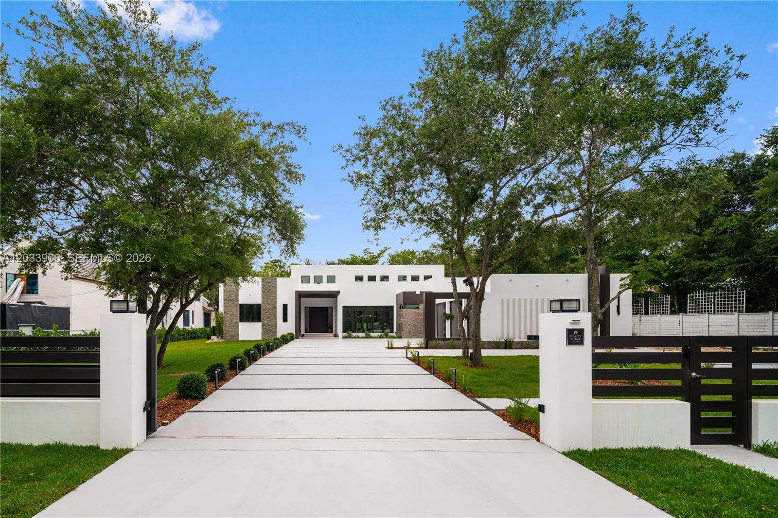 A modern white single-story house with a long concrete driveway and gated entrance — 6200 SW 83 Av, Miami FL 33143, MIAMI, FL