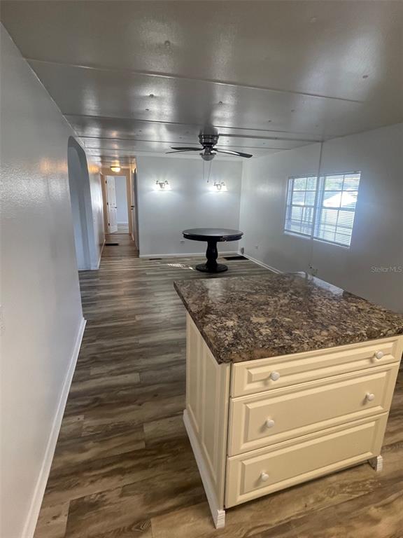 A kitchen island with a stone countertop sits in a room with wood-look flooring — 4421 TODD AVENUE, ORLANDO, FL