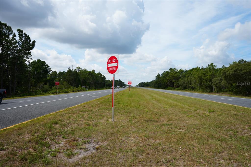 A view of a divided highway with a Do Not Enter sign in the foreground — 18284 COMMERCIAL WAY, WEEKI WACHEE, FL