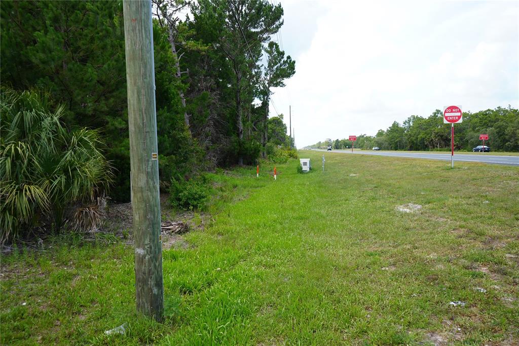 A grassy roadside lot with a utility pole and a Do Not Enter sign — 18284 COMMERCIAL WAY, WEEKI WACHEE, FL