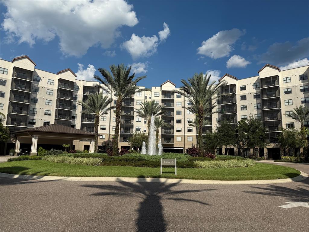 A multi-story apartment building features a circular driveway with a central fountain and palm trees — 14501 GROVE RESORT AVE UNIT 1622, WINTER GARDEN, FL