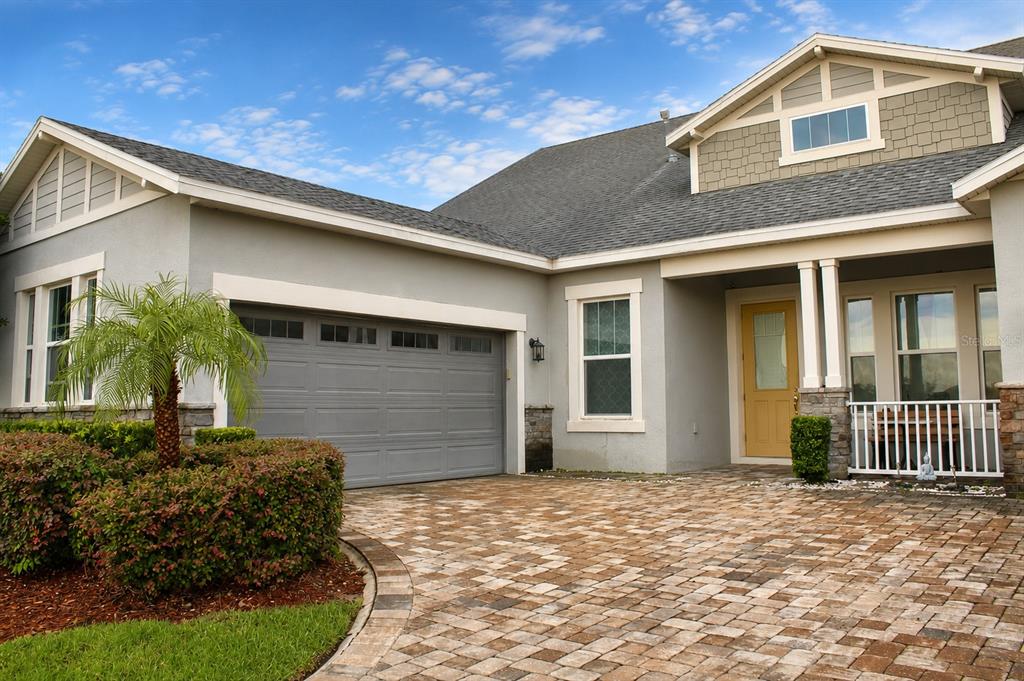A single-story house with a gray stucco exterior, a two-car garage, and a paved driveway — 14779 MCCLANE ROAD, WINTER GARDEN, FL