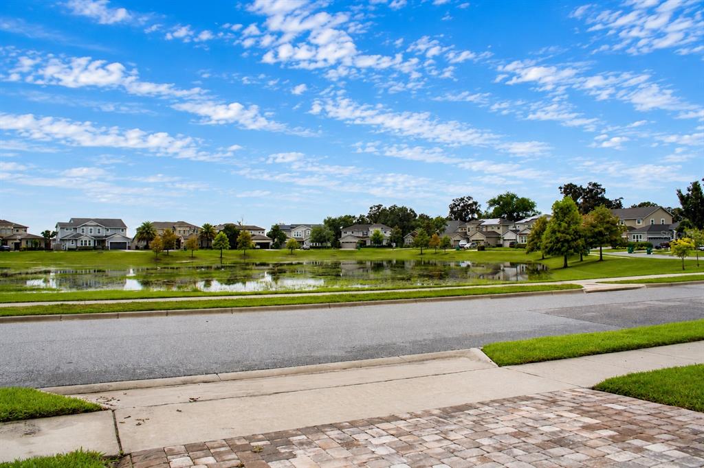A view of a suburban neighborhood street facing a pond and residential houses — 14779 MCCLANE ROAD, WINTER GARDEN, FL