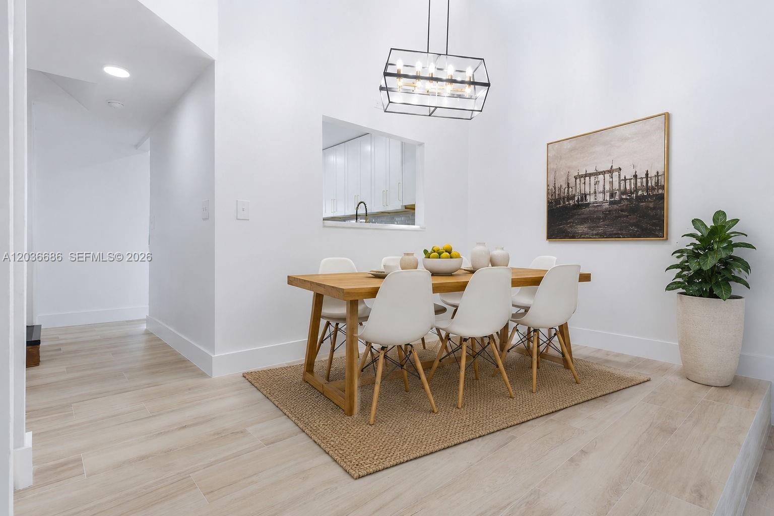 A dining room features a wooden table, white chairs, a jute rug, and a pendant light — 2152 SW 81st Way, Davie FL 33324, DAVIE, FL
