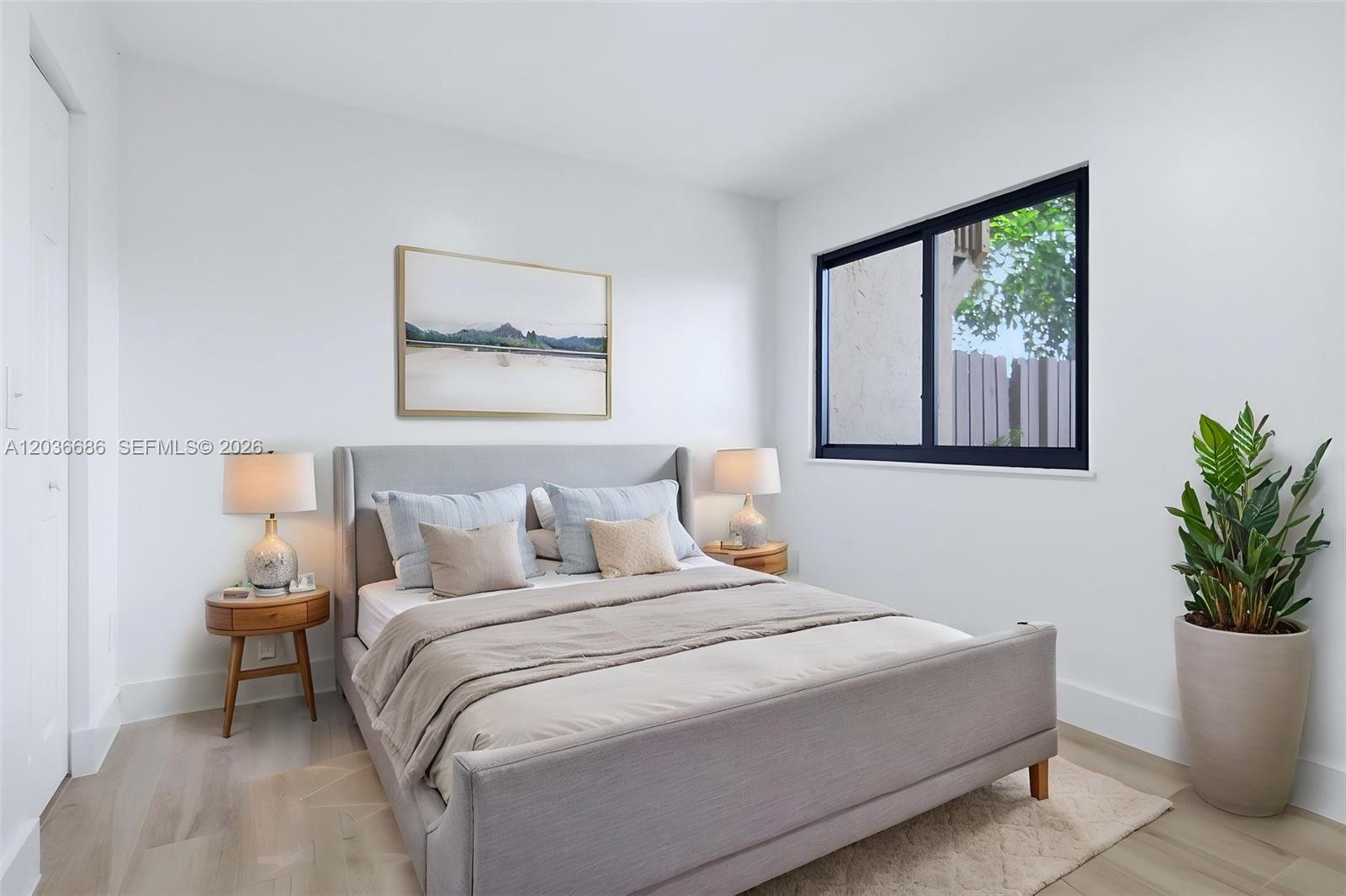 A bedroom features a gray upholstered bed, two wooden nightstands, and a potted plant — 2152 SW 81st Way, Davie FL 33324, DAVIE, FL