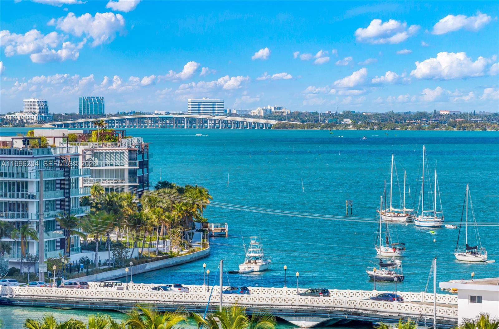 An elevated view of a bay featuring a bridge, several sailboats, and waterfront apartment buildings — 1621 Bay Rd # 802, Miami Beach FL 33139, MIAMI BEACH, FL