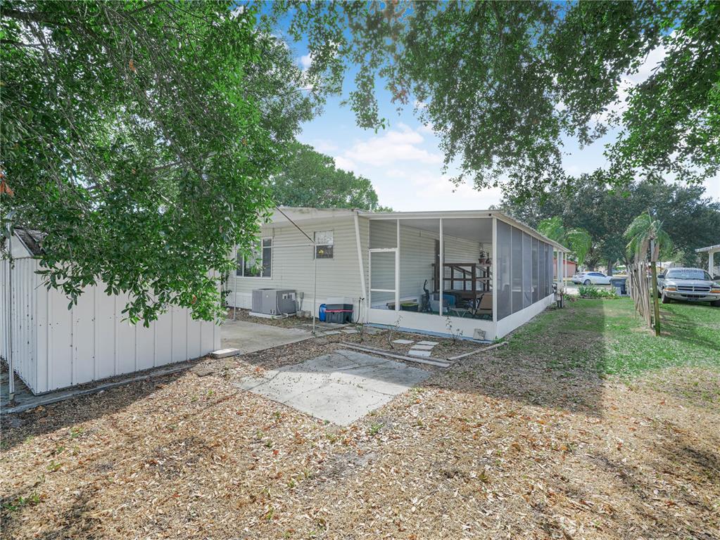 A mobile home with a screened-in porch and a detached storage shed in the backyard — 319 1ST AVENUE N, LAKE WALES, FL
