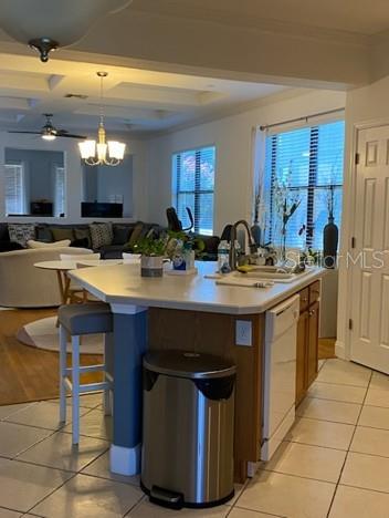 A kitchen island with a stainless steel trash can sits in front of a living area — 10076 SILVER LAUREL WAY, ORLANDO, FL