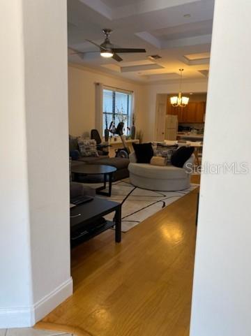 A living room with hardwood floors, a ceiling fan, and a curved sofa on a rug — 10076 SILVER LAUREL WAY, ORLANDO, FL