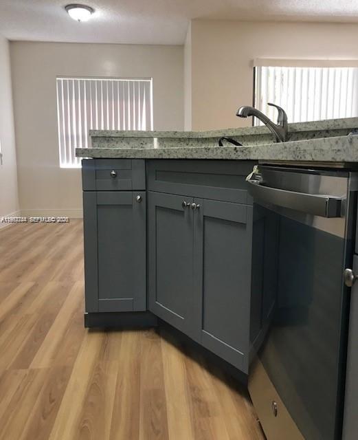 A kitchen features gray cabinets, a granite countertop, and a stainless steel dishwasher — 9999 Summerbreeze Dr # 414, Sunrise FL 33322, SUNRISE, FL