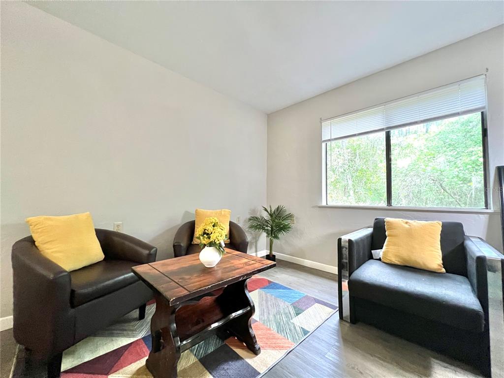 A room features three dark chairs, a wooden coffee table, and a geometric area rug — 81 SE 16TH AVENUE UNIT D101, GAINESVILLE, FL