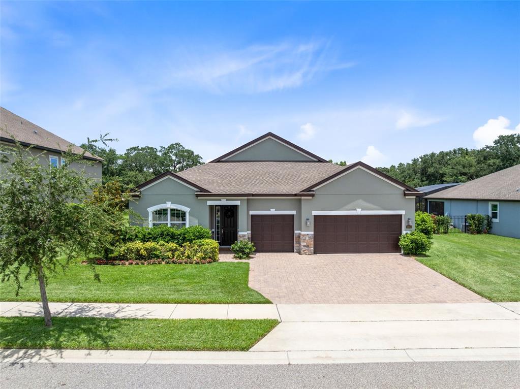 A bright living room features a light-colored sofa, two armchairs, a coffee table, and windows — 1743 FULLERS OAK LOOP, WINTER GARDEN, FL