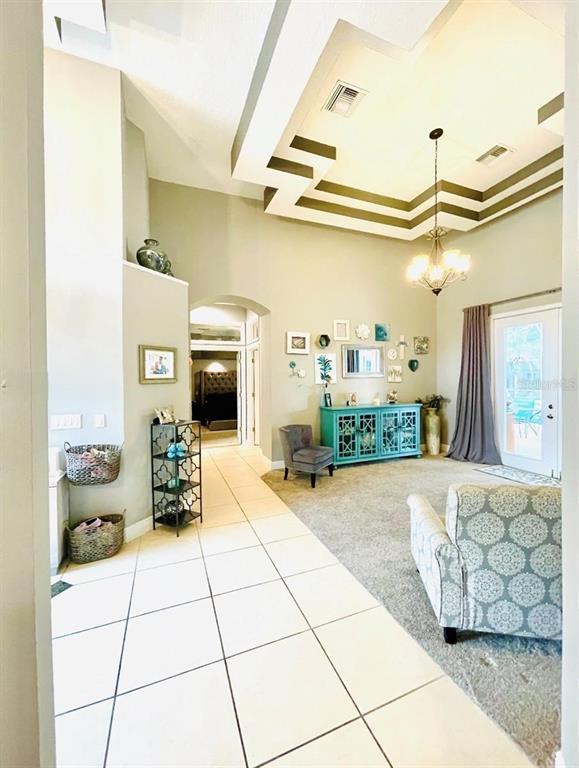 A bright entryway with tile flooring leads to a formal dining room with carpet — 330 GLEN CLUB DRIVE, DEBARY, FL