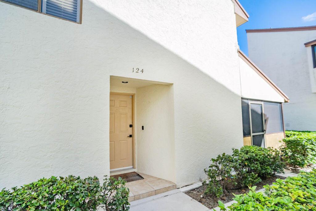 The exterior of a tan stucco building features a front door labeled 124 — 950 S Kanner Hwy Highway # 124, Stuart FL 34994, STUART, FL